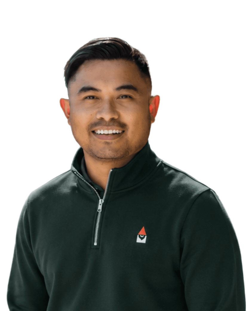 Brian Enad, co-founder and CTO, photographed from the shoulders up in a dark green Knome quarter-zip.