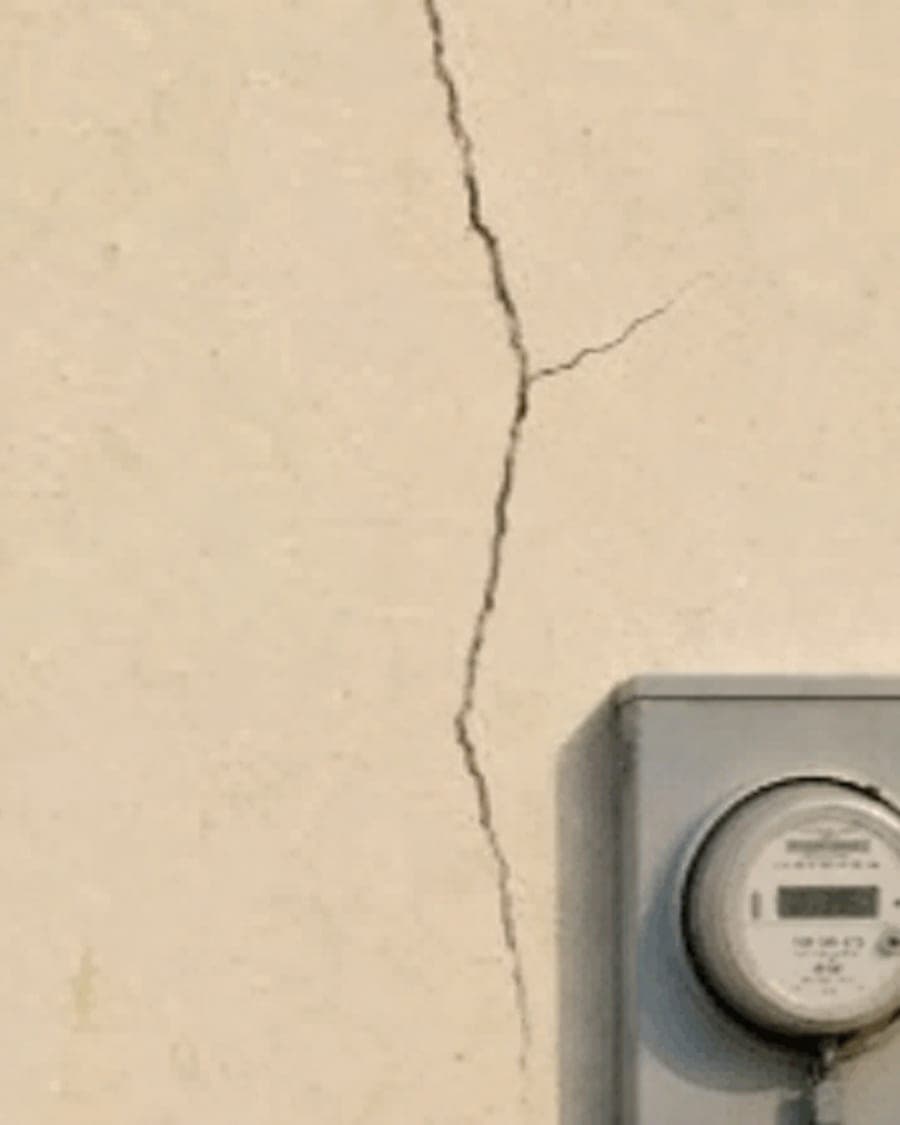 The same cracked wall and meter box after WhatsApp compression to 480p, where the crack reads as a smudge and the meter is illegible.