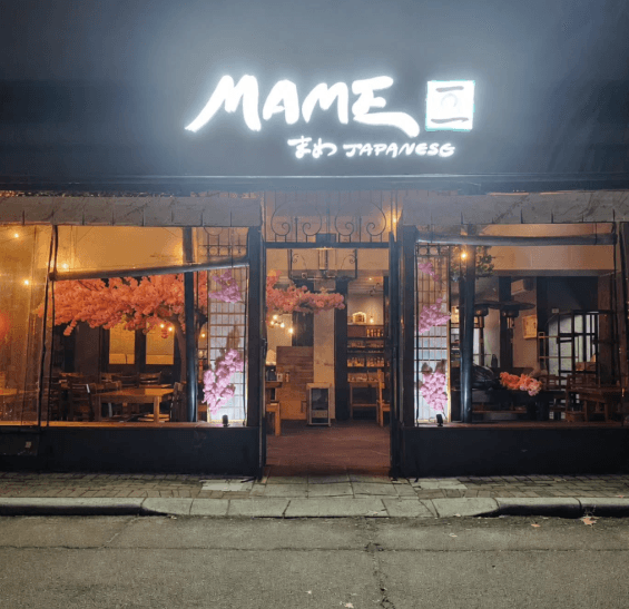 The lit shopfront of Mame Japanese on Walcott Street, Mount Lawley, at night.